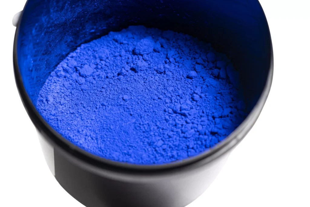 Bowl of vibrant blue pigment powder.