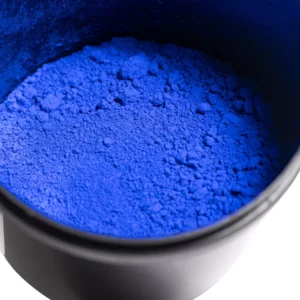 Bowl of vibrant blue pigment powder.