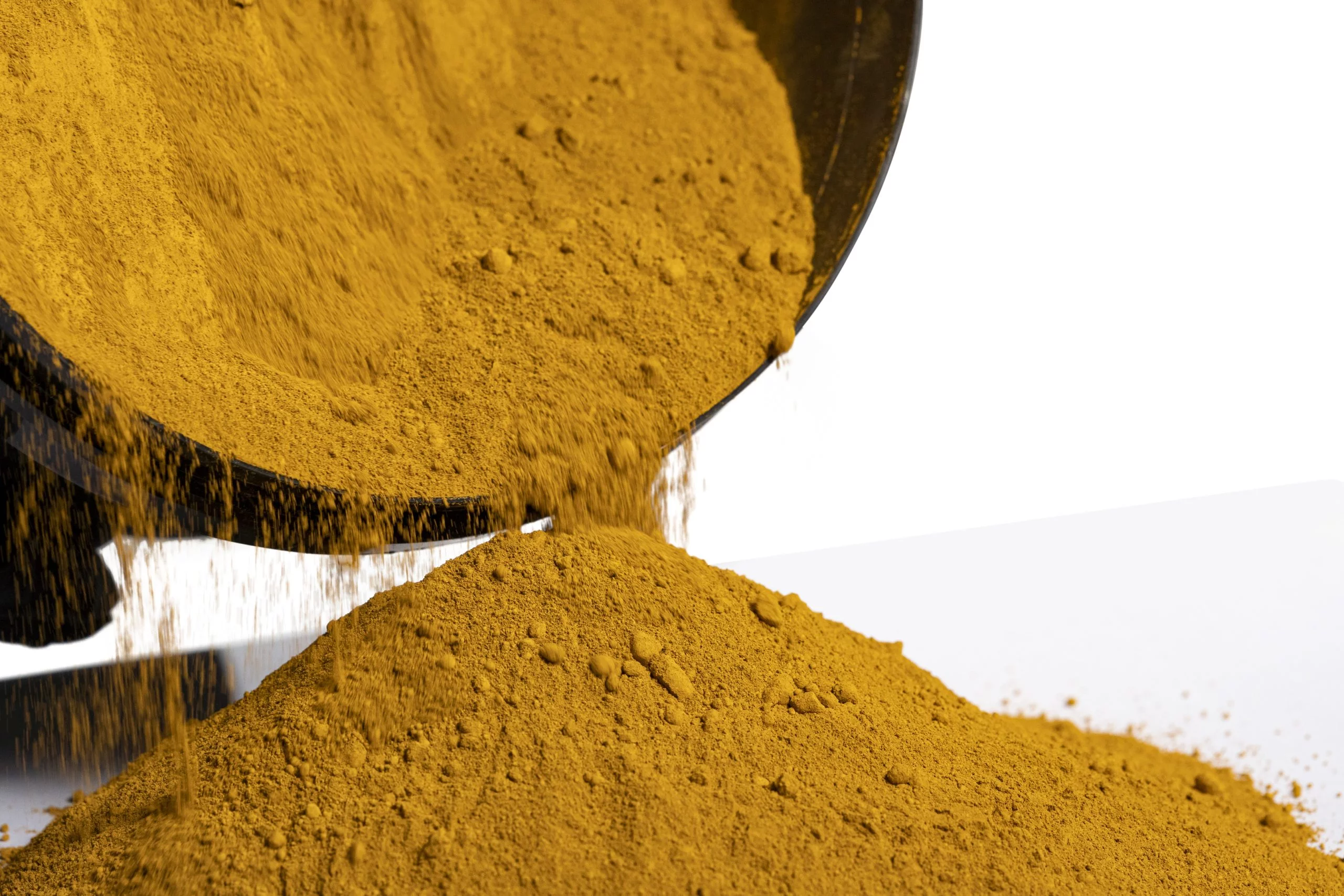 Pouring turmeric powder into a pile.