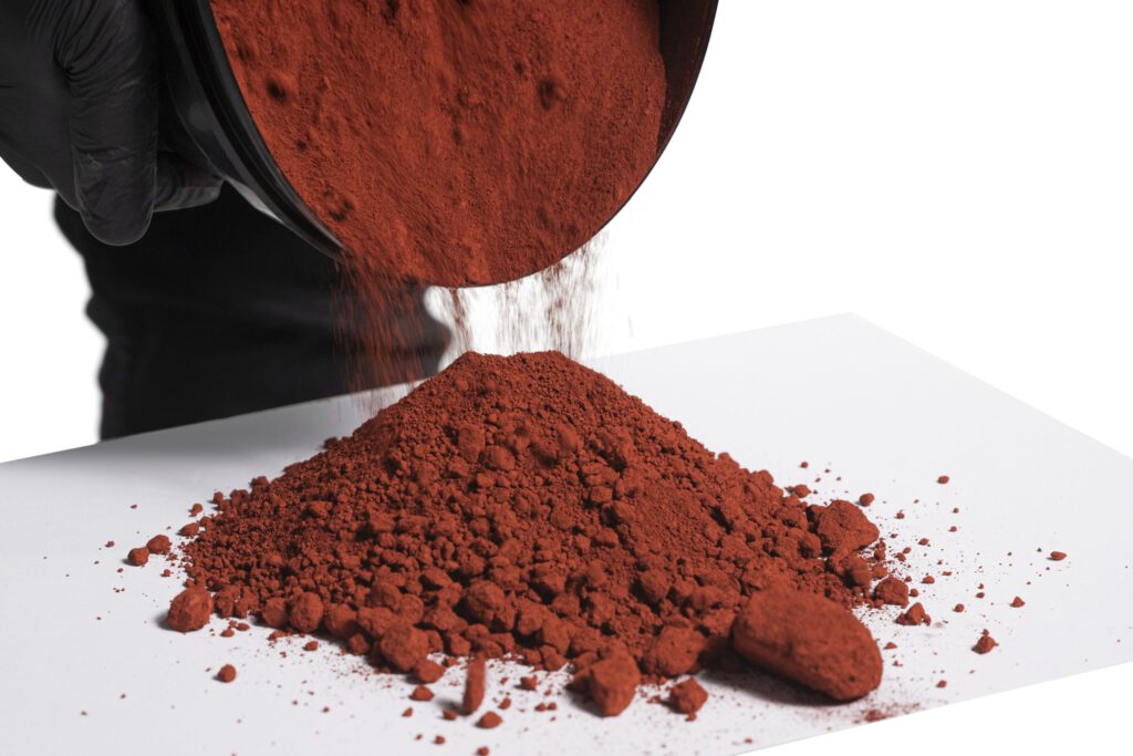 Pouring red powder onto white surface