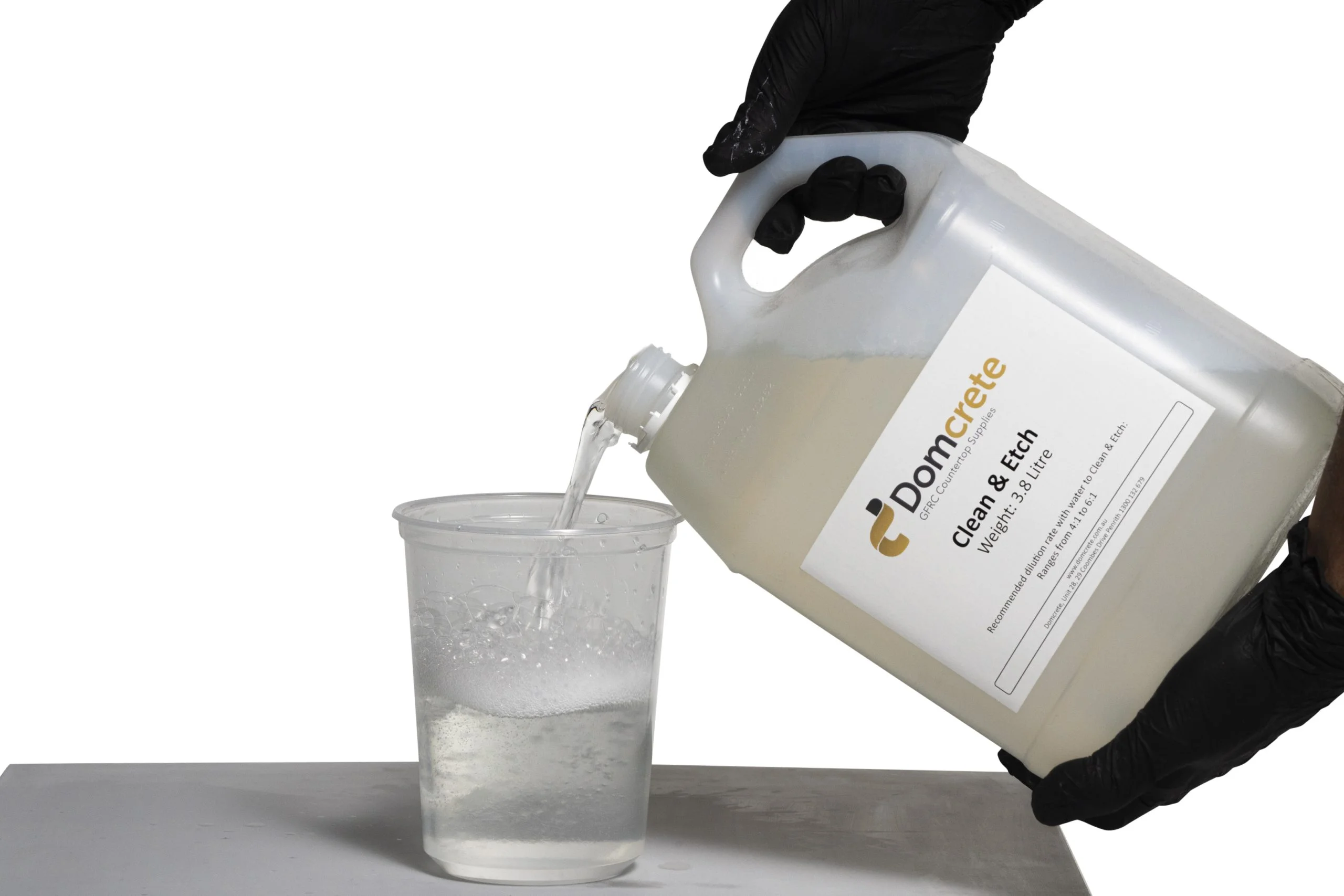 Pouring Domcrete Clean & Etch into plastic cup.