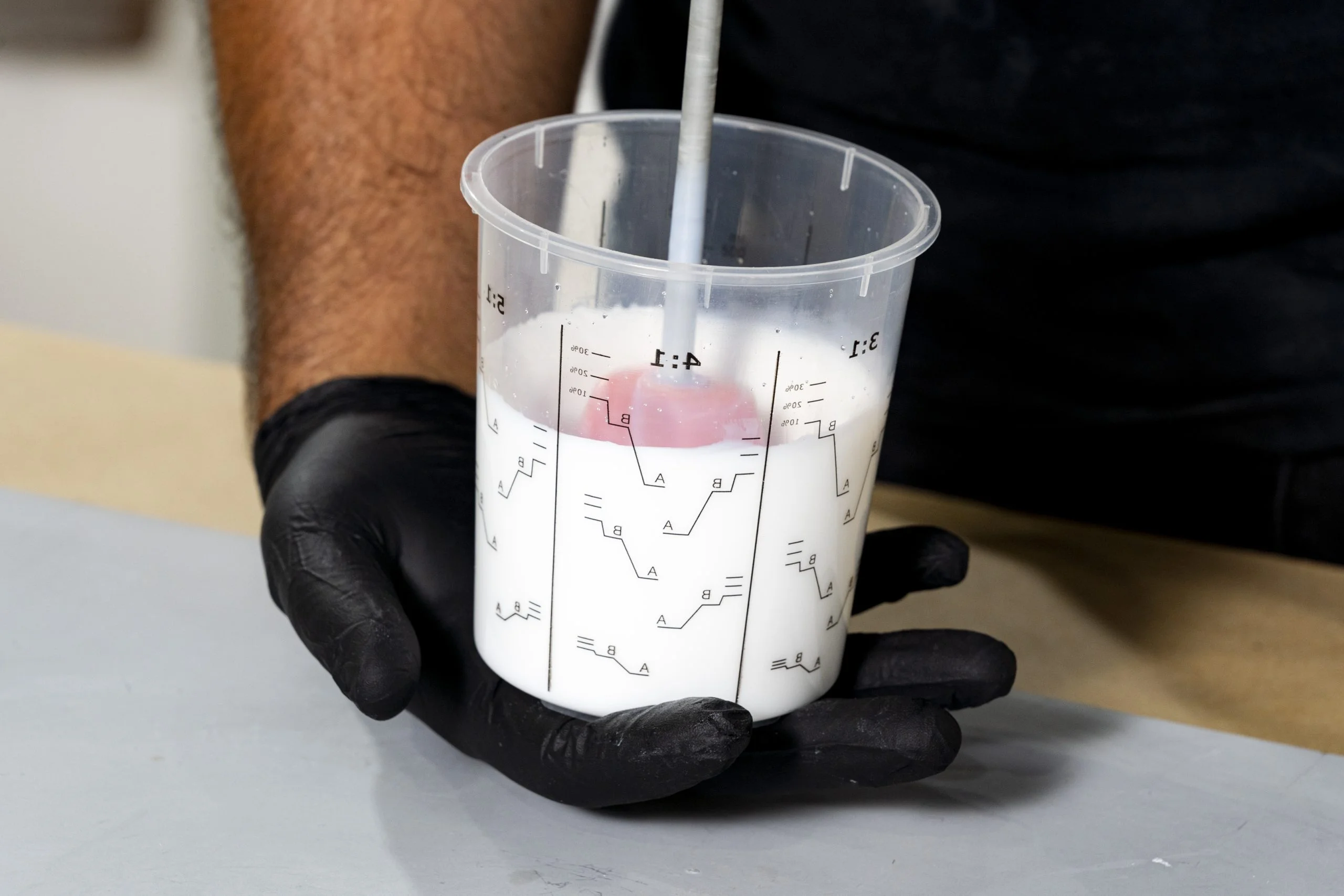 Person mixing paint in a container
