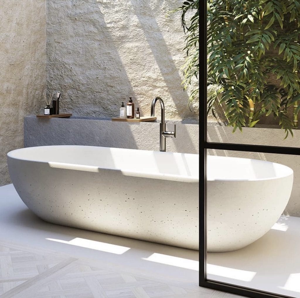 Modern bathroom with freestanding tub and plants.