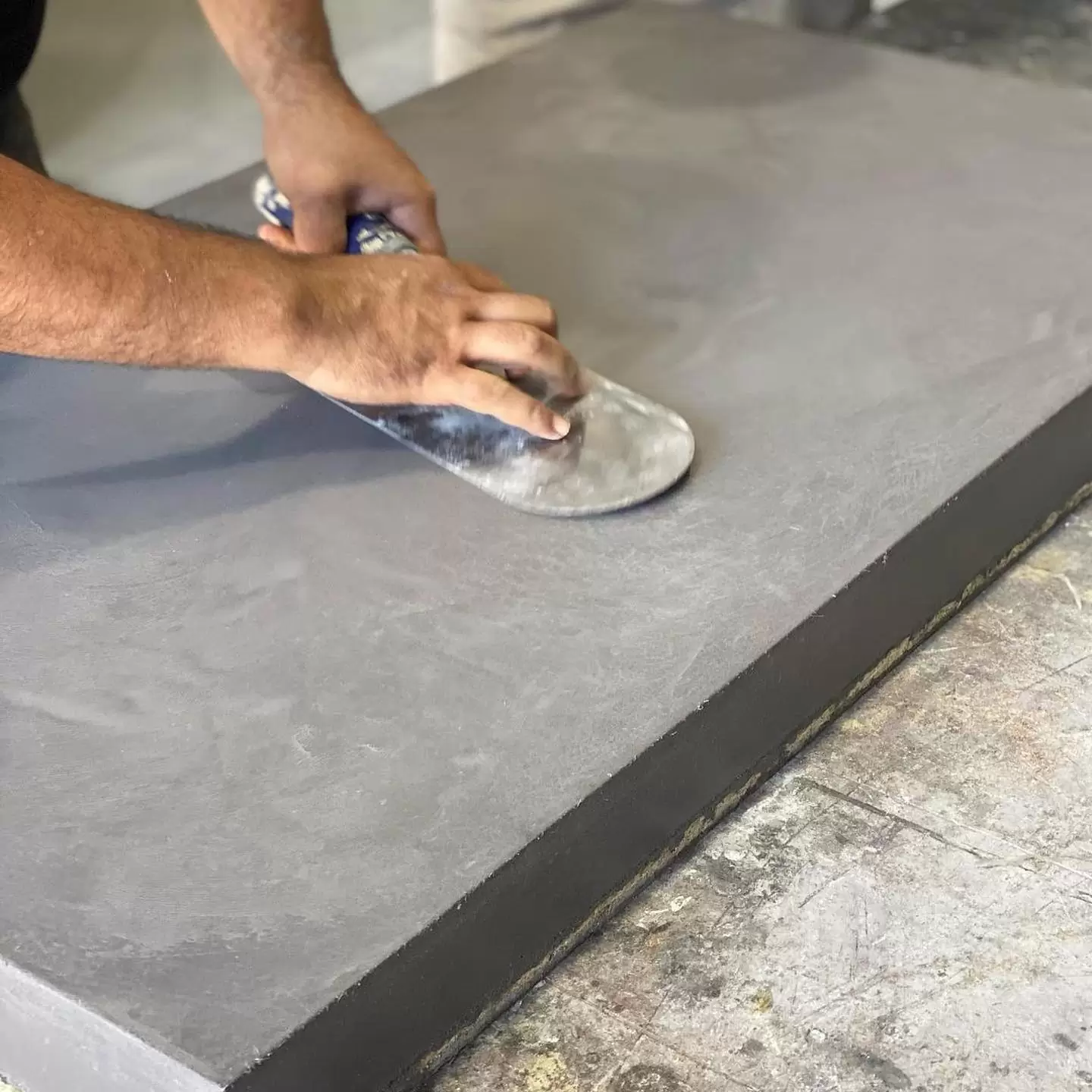 Craftsman smoothing concrete with trowel tool