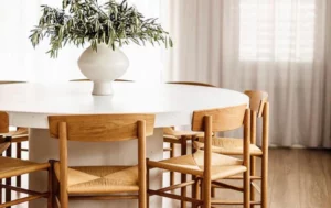 Modern dining table with wooden chairs and vase