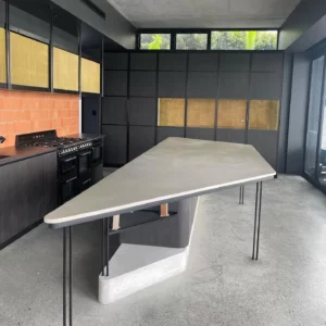 Modern kitchen with a triangular concrete island.