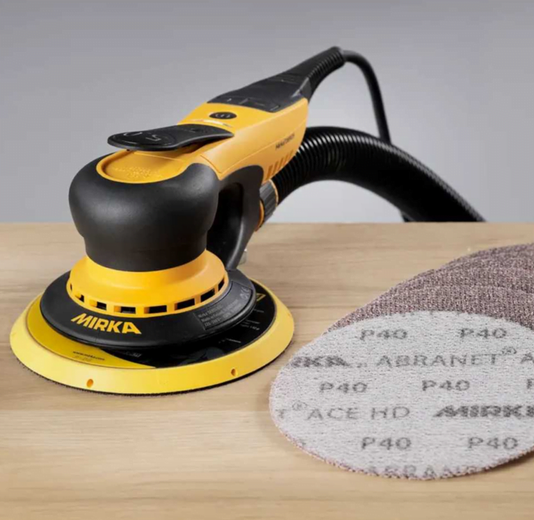 Mirka sander with sanding discs on wooden surface
