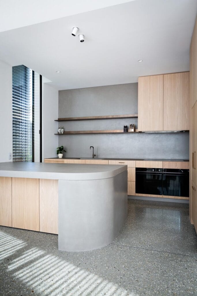 Modern kitchen with light wood cabinets and bench.