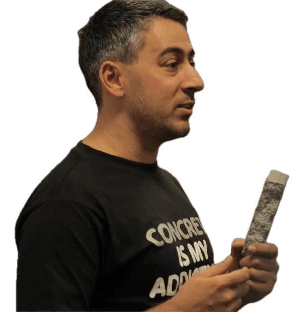 Man holding concrete sample, wearing themed t-shirt.
