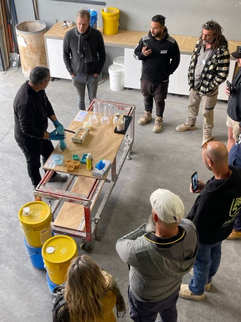 People observing a demonstration in a workshop.