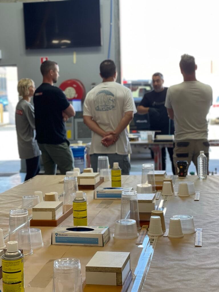 Group discussing around workshop table with supplies.