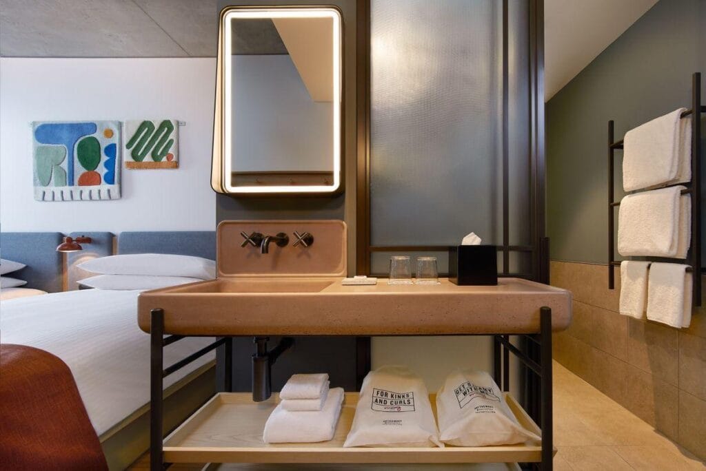 Stylish hotel room with modern sink and towels.