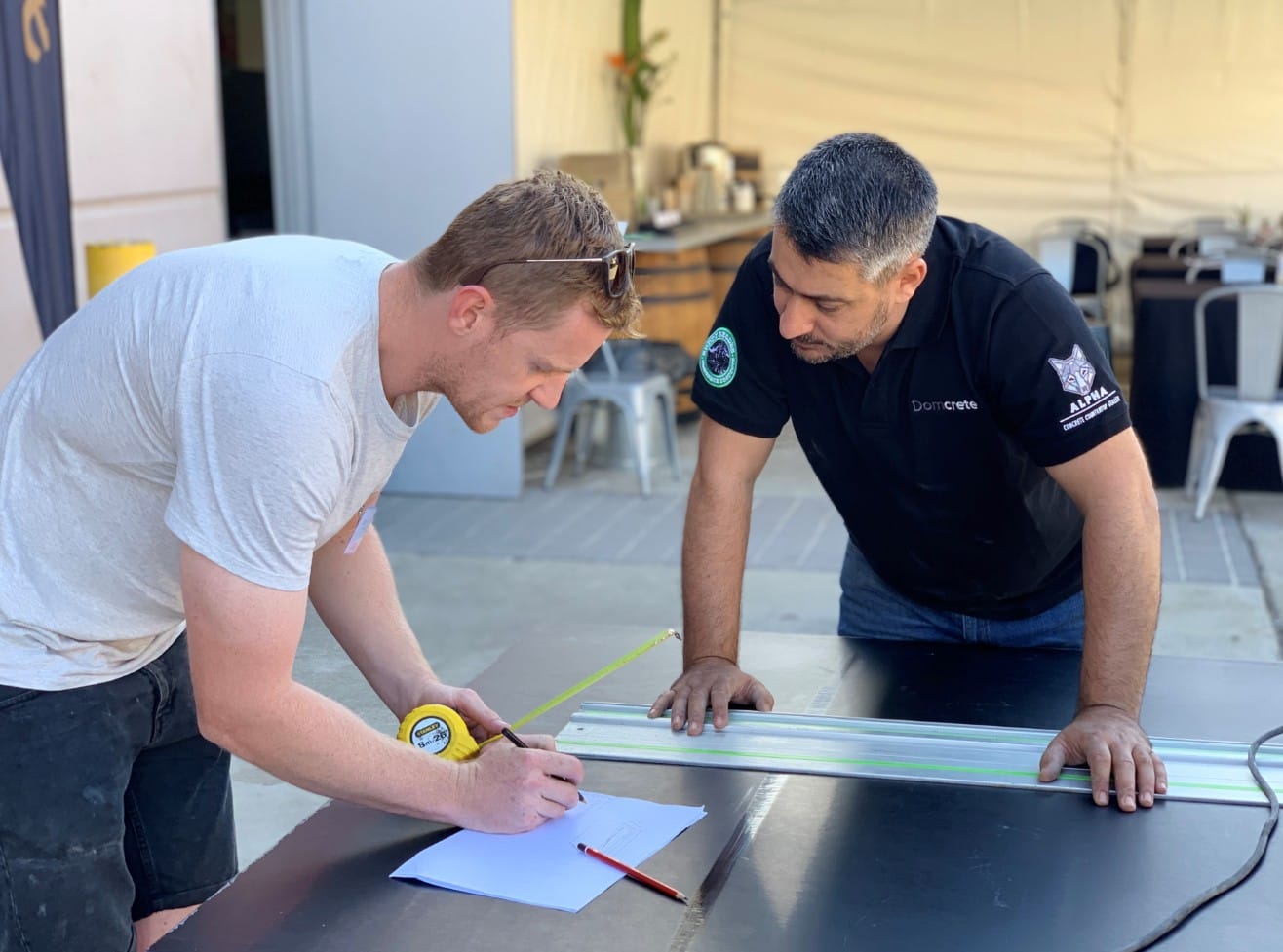 Two men measuring and planning on a table